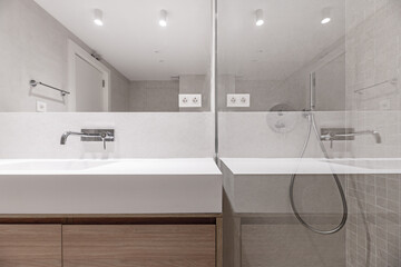 A modern design bathroom with an integrated mirror that runs along the entire wall