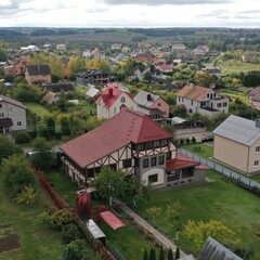 Fototapeta na wymiar Picturesque cottage village in Europe with houses and private area (plots, vegetable gardens, fields) in bad weather, aerial view from a drone. Houses in English and Dutch style.