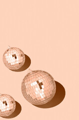 Color of the year 2024 peach fuzz..Shiny disco balls. Creative Christmas pattern. 90s retro party time concept. Xmas holiday background. Top view. Flat lay