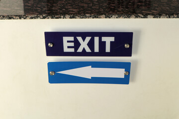 Exit sign with a white arrow on a blue background.