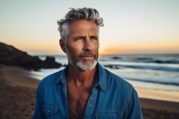 Portrait of a tender man in his 50s sporting a versatile denim shirt against a stunning sunset...