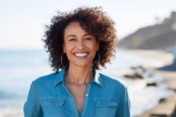 Portrait of a cheerful afro-american woman in her 40s sporting a versatile denim shirt against a peaceful tide pool background. AI Generation - obrazy, fototapety, plakaty