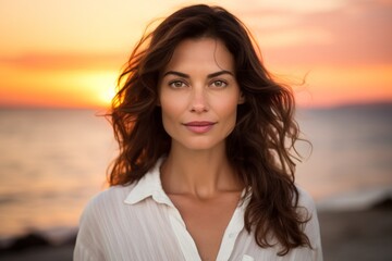 Portrait of a content woman in her 30s wearing a simple cotton shirt against a vibrant beach sunset background. AI Generation