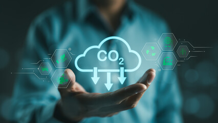 Carbon footprint concept. Man hand holding carbon reduction icon. Net zero and carbon neutral, Carbon emissions, CO2 neutrality, Sustainable energy, Climate change, Global warming, Greenhouse gas, - obrazy, fototapety, plakaty