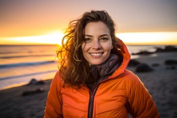 Portrait of a cheerful woman in her 30s donning a durable down jacket against a vibrant beach sunset background. AI Generation