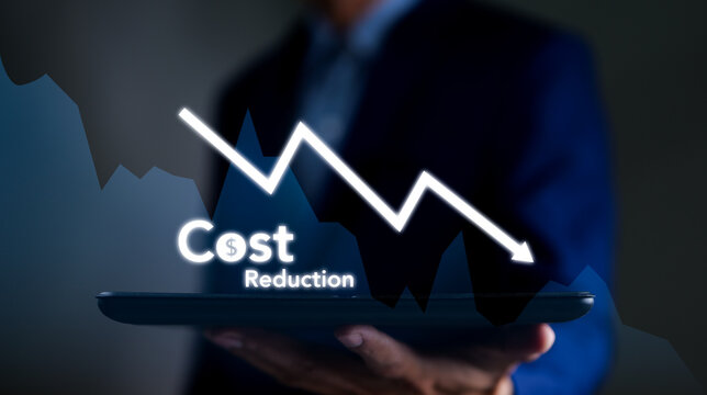 Businessman working on company cost saving. Cost wording on decreasing coins stacking with the down arrow. Cost Management, Economy recession, low budget, Effective business, Cost reduction concept.