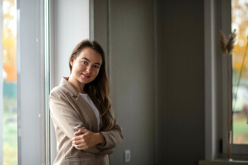 A smiling businesswoman. A small business entrepreneur stands near the window in her office