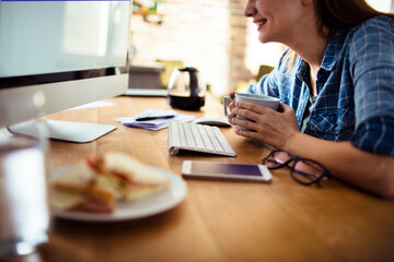 Woman working from home with coffee and smartphone