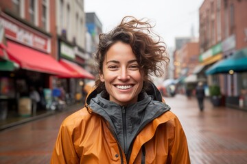 Portrait of a joyful woman in her 30s wearing a functional windbreaker against a vibrant market street background. AI Generation - obrazy, fototapety, plakaty