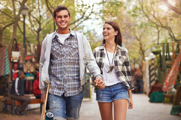 Smile, walking and couple holding hands on city journey, morning trip or weekend tour of urban Spain for outdoor adventure. Love, skateboard and young people bonding together on relax commute
