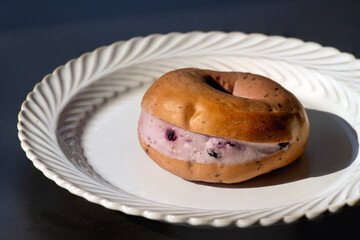 Blueberry cheese bagel on white plate