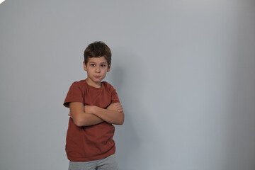 A stern-faced child with arms folded signifies resilience. Echoes the need for understanding youth...