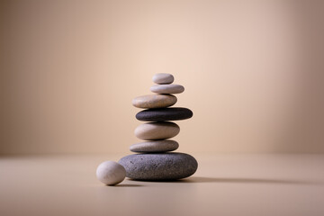Balancing pebble stones on beige background