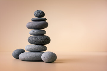 Balancing pebble stones on beige background