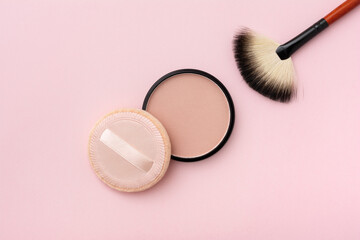 Mineral compact powder, make-up brush and sponge, isolated on a pink background - obrazy, fototapety, plakaty