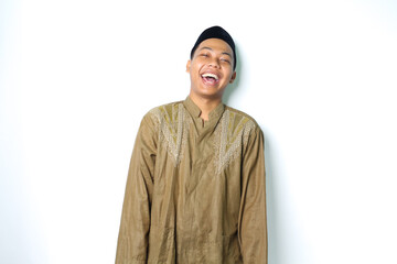 laughing asian moslem man wearing koko clothes standing over isolated white background