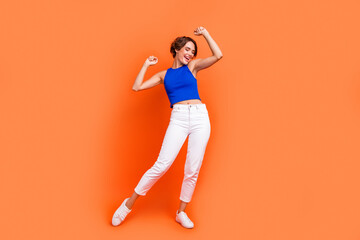Fototapeta na wymiar Full length portrait of carefree stunning cheerful person enjoy dancing partying isolated on orange color background