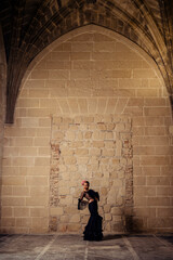 Chica joven rubia con traje flamenco posando en antiguo monasterio