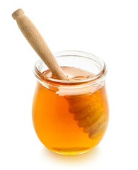 Glass jar full of honey and wooden dipper on white background