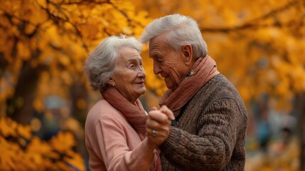an elderly couple dancing together outdoors, surrounded by the warm colors of autumn leaves.  