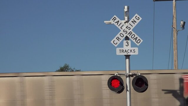 Freight train passes level road railway crossing, USA