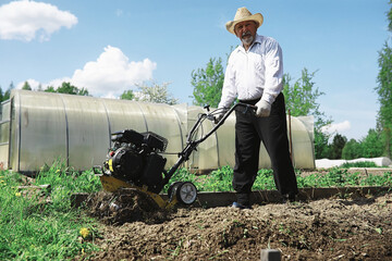 The farmer is digging a garden. The harvester plows the garden. The gray-haired grandfather mows...