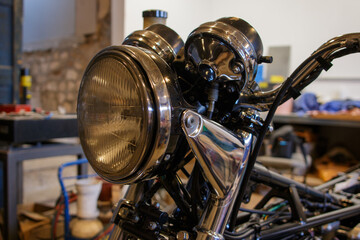 phare et compteur de vitesse d'une moto vintage dans un atelier