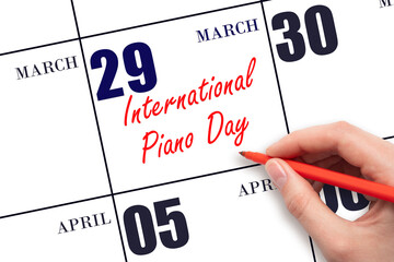 March 29. Hand writing text International Piano Day on calendar date. Save the date.