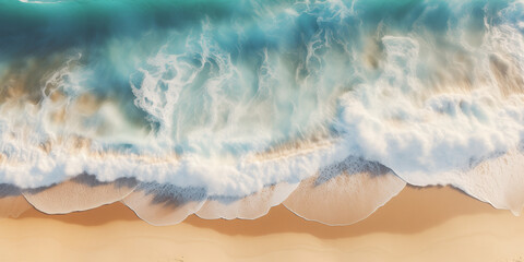Blue waves roll onto white sand, view from above