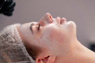 close-up of a girl's face with a cream or mask during a cosmetic procedure in a beauty salon