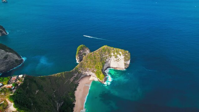 Famous Kelingking T-Rex sightseeing spot landmark at Nusa Penida Island, Bali, Indonesia. Aerial drone footage at daytime with beautiful ocean waves