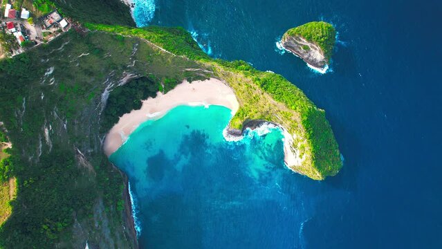Famous Kelingking T-Rex sightseeing spot landmark at Nusa Penida Island, Bali, Indonesia. Aerial drone footage at daytime with beautiful ocean waves