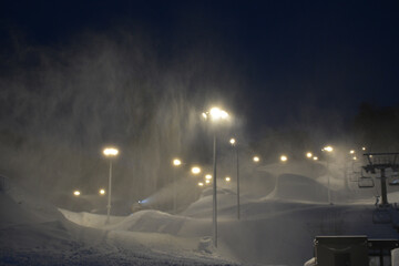 Blizzard, a lot of snow at the ski resort. Ski cable car and lamps illuminate the slopes