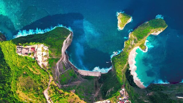 Famous Kelingking T-Rex sightseeing spot landmark at Nusa Penida Island, Bali, Indonesia. Aerial drone footage at daytime with beautiful ocean waves