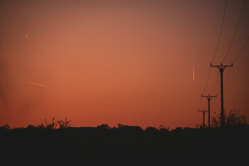 Silhouettes of electricity poles at sunset. Renewable energy