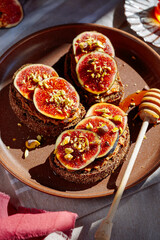 Sandwich with figs and nuts drizzled with honey, sunlight, no people, close-up.