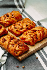 freshly baked croissants with pecans, on a wooden board, light background