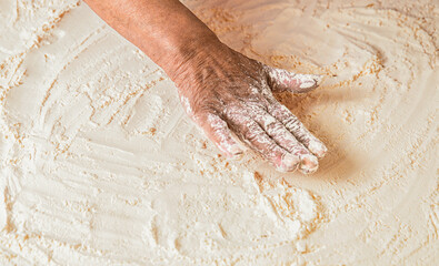 Dough on white powder covered table. Hand flour. Hands baker with flour in kitchen. Hands woman covered in flours. Women's hands, flour and dough. Woman preparing dough for home baking