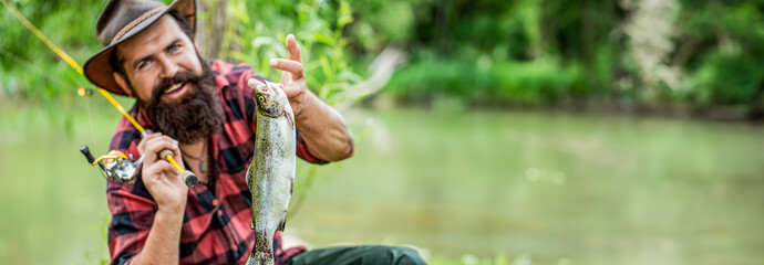 Angler with fishing trophy. Fisherman and trout. Fishing backgrounds. Man hold big fish trout in...