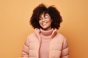 Portrait of a satisfied afro-american woman in her 30s sporting a quilted insulated jacket against...