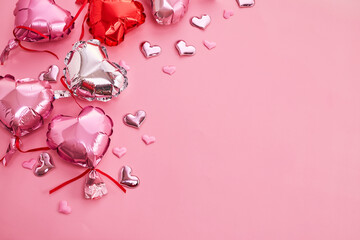 Air Balloons of heart shaped foil on pastel pink background. Valentine's Day decoration.