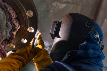 Welder working on flange for new line manufacturing
