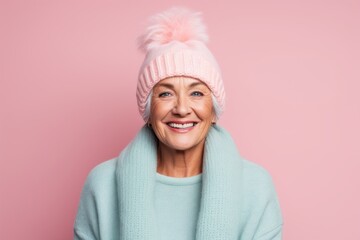 Portrait of a glad woman in her 70s donning a warm wool beanie against a pastel or soft colors...