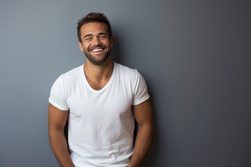 Fototapeta premium Portrait of a grinning man in his 30s donning a trendy cropped top against a minimalist or empty room background. AI Generation