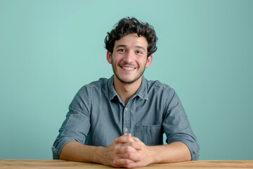Young Man in Thoughtful Pose Against a Soft Blue Backdrop