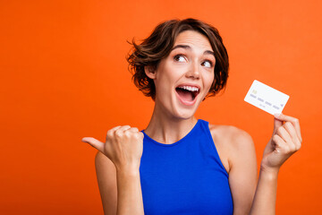 Portrait of cute impressed person arm hold plastic debit card look indicate finger empty space...