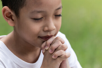 Little boy with Bible praying and close your eyes in praying. Prayer to pray. Children pray with...