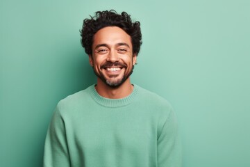 Portrait of a joyful man in his 30s wearing a cozy sweater against a solid pastel color wall. AI...