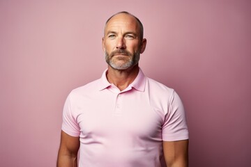 Obraz premium Portrait of a content man in his 40s wearing a breathable golf polo against a solid pastel color wall. AI Generation