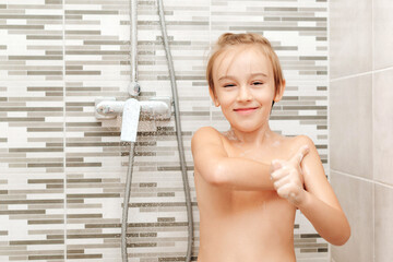 Cute child washing himself in shower.